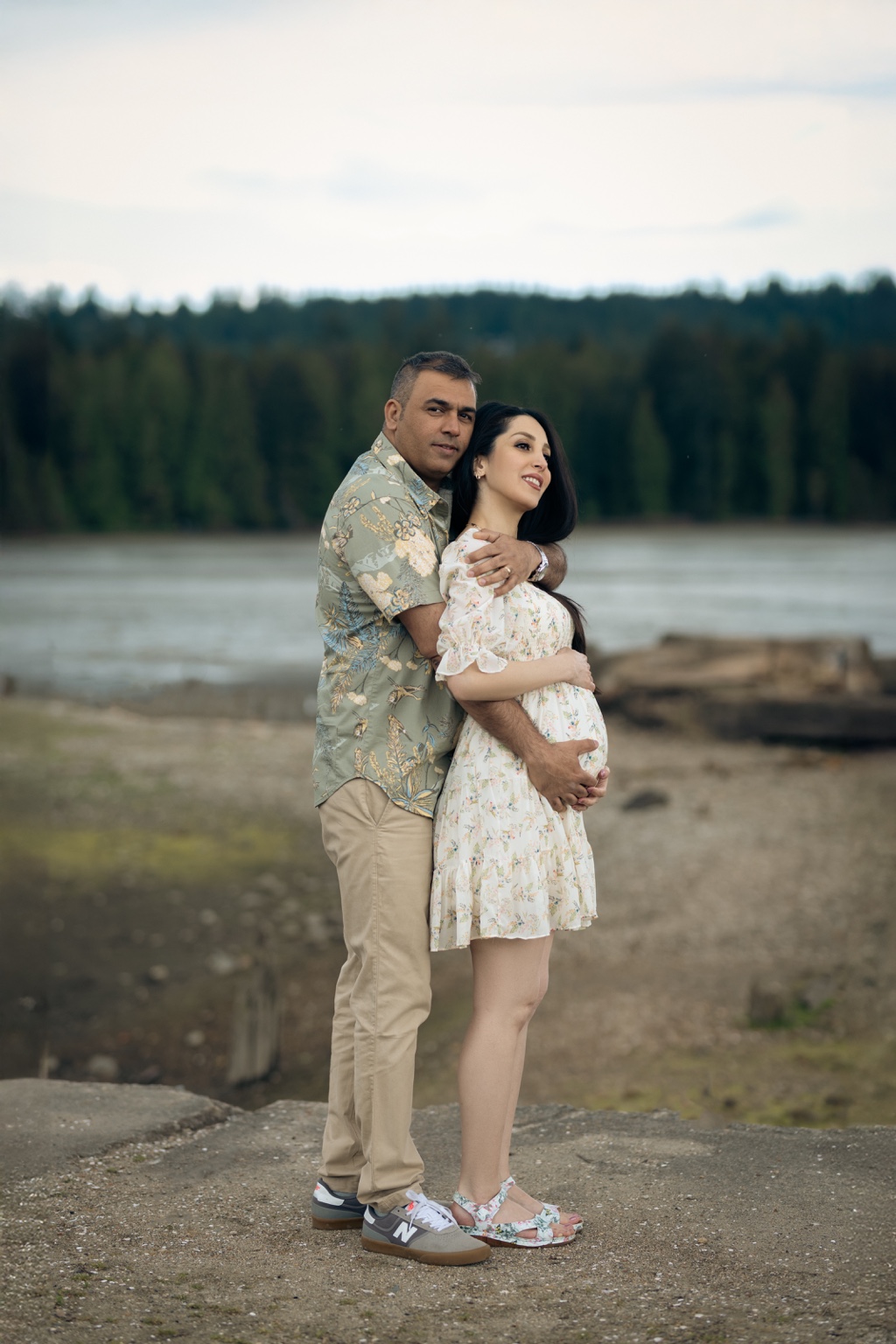 Expecting couple embracing during a lakeside maternity session